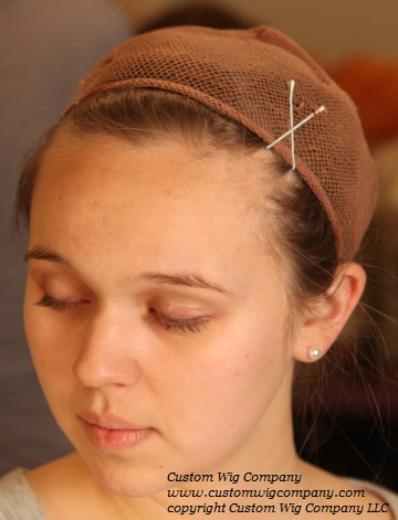 Hair pinned up under a wig cap
