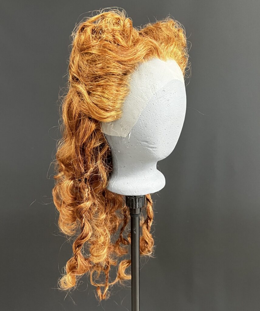 red 16th century style wig on grey foam head